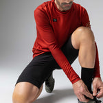 Man wearing red Gobik Terrain long sleeve athletic shirt in dynamic pose