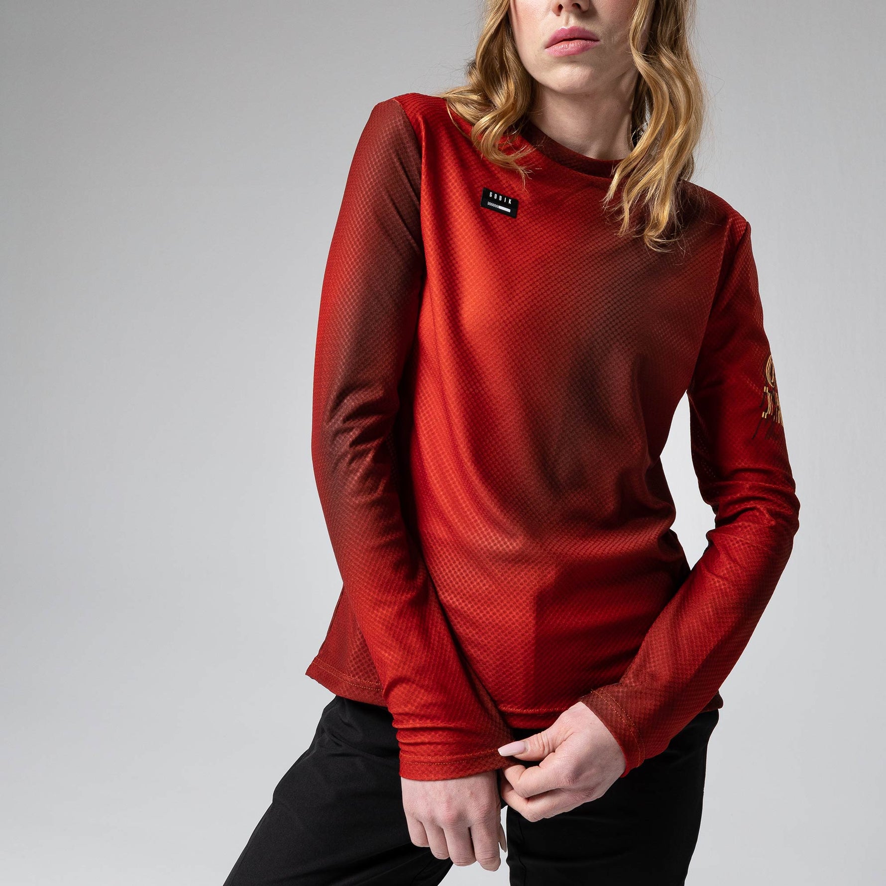 Woman wearing red Gobik Terrain long sleeve t-shirt with textured fabric pattern