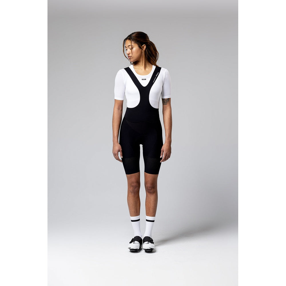 Woman wearing black Gobik Ultralite cycling bib shorts with white base layer