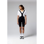 Woman wearing black Gobik Ultralite cycling bib shorts with white base layer