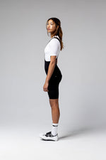 Woman wearing black Gobik Ultralite cycling bib shorts with white jersey