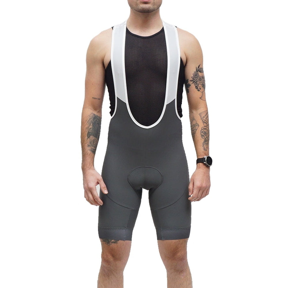 Man wearing grey Legg Plus bibshorts with white suspenders and black mesh tank top