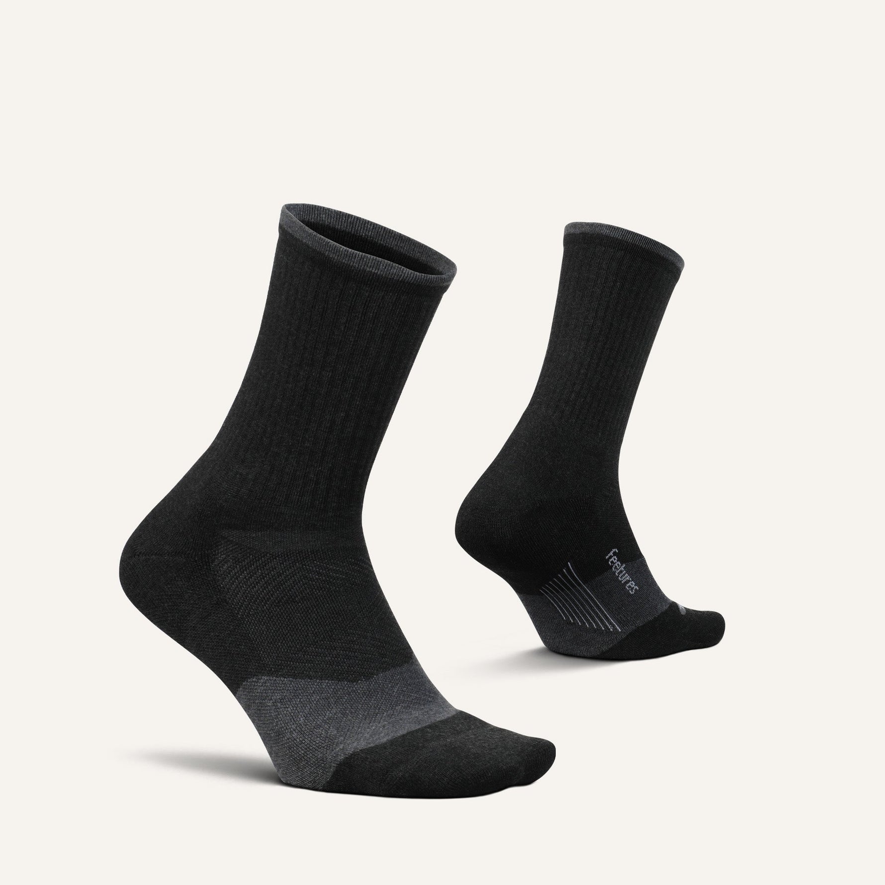 Pair of black Feetures Trail Max Cushion Mini Crew socks on clean background