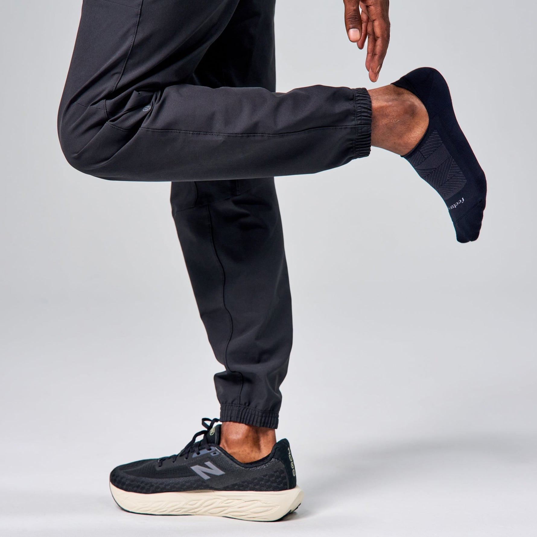 Feetures Elite Light Cushion Invisible black no-show socks worn by male model in running gear