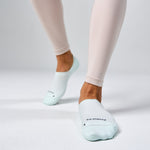 Feetures Elite Light Cushion Invisible socks in Ice color worn on model's feet