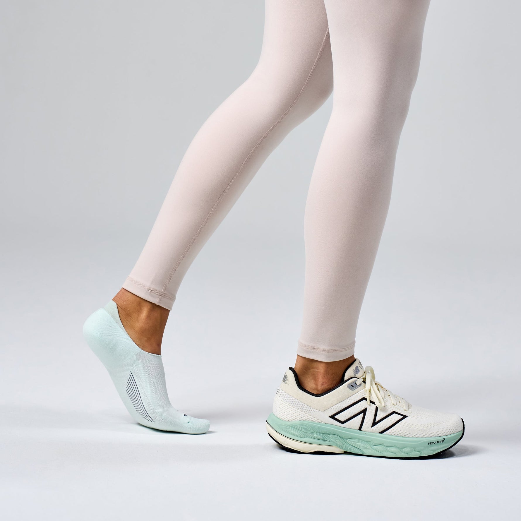 Feetures Elite Light Cushion Invisible sock in mint worn with New Balance sneakers