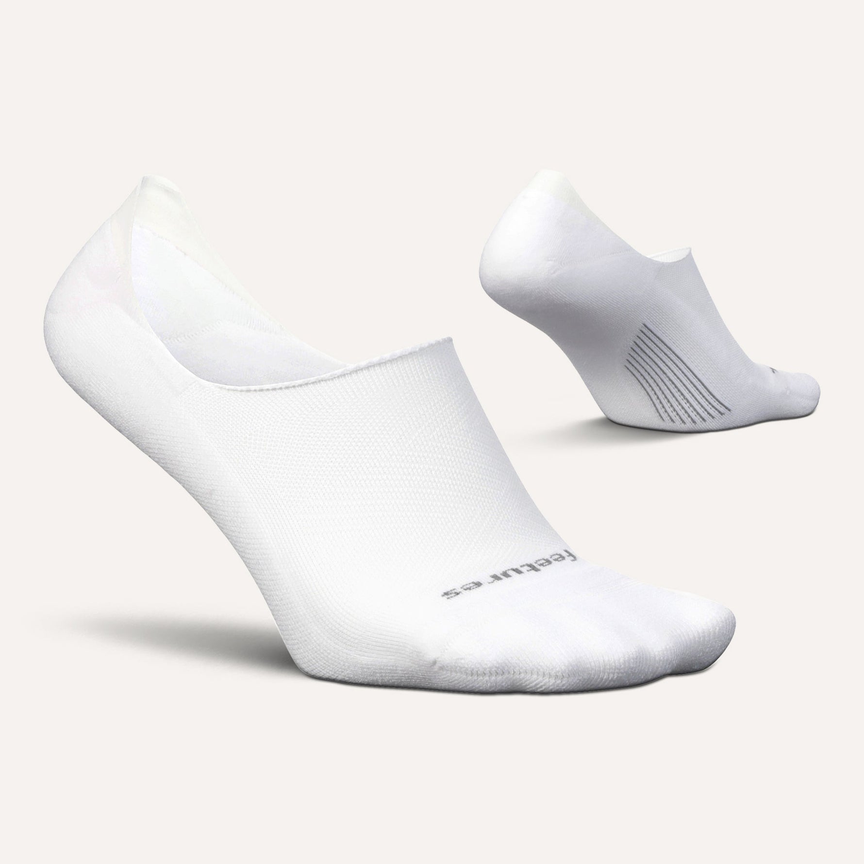 Two white Feetures Elite Light Cushion no-show socks on clean background