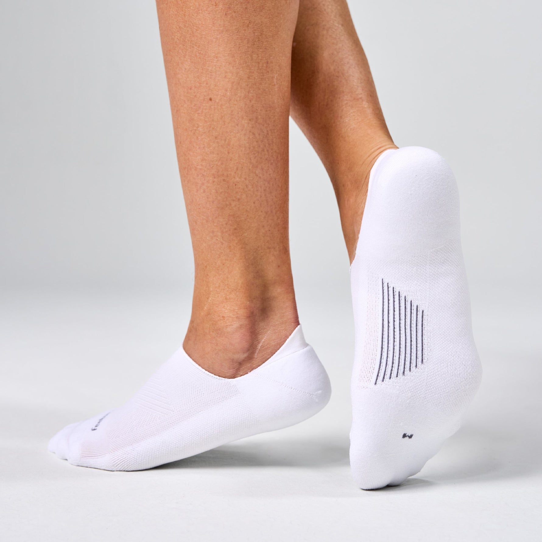 White Feetures Elite Light Cushion Invisible no-show socks on feet