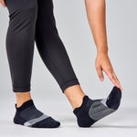 Feetures Elite Light Cushion Tab socks in black with gray pattern on model's feet