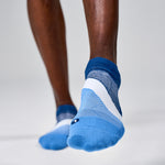 Feetures Elite Light Cushion Tab socks in blue gradient on model's feet