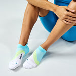 Feetures Elite Light Cushion Tab socks in blue and green colorblock design on model
