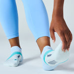 Person putting on Feetures Elite Light Cushion Tab socks in light blue and teal
