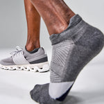 Grey Feetures Elite Light Cushion Tab socks worn with running shoes during exercise