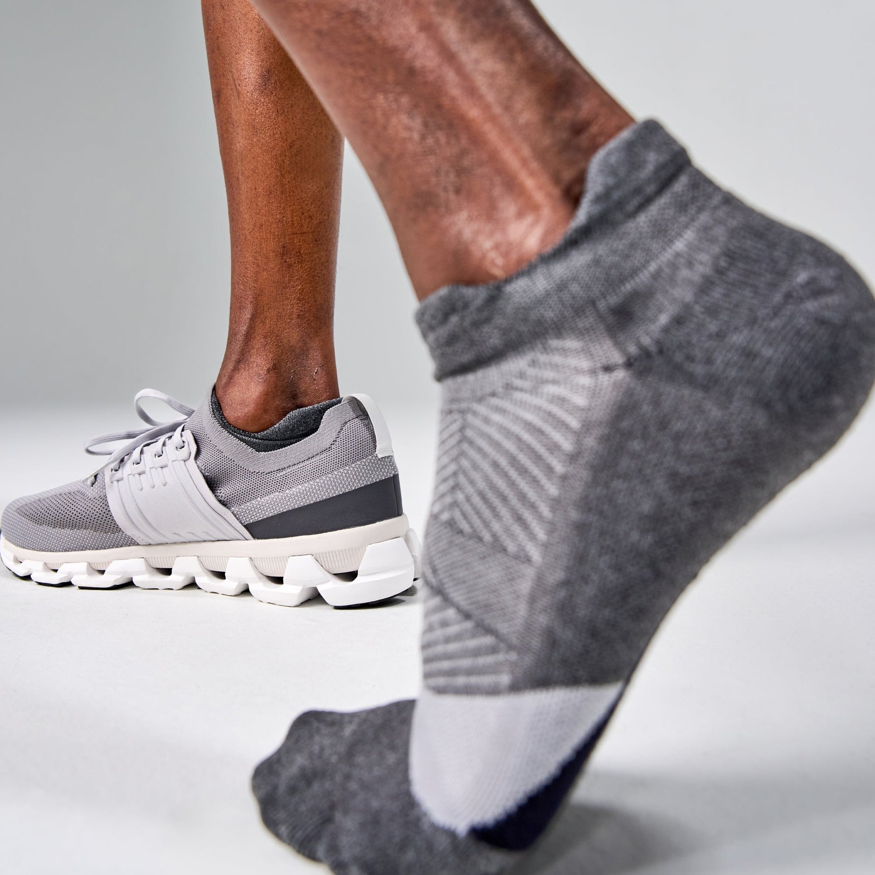 Grey Feetures Elite Light Cushion Tab socks worn with running shoes during exercise