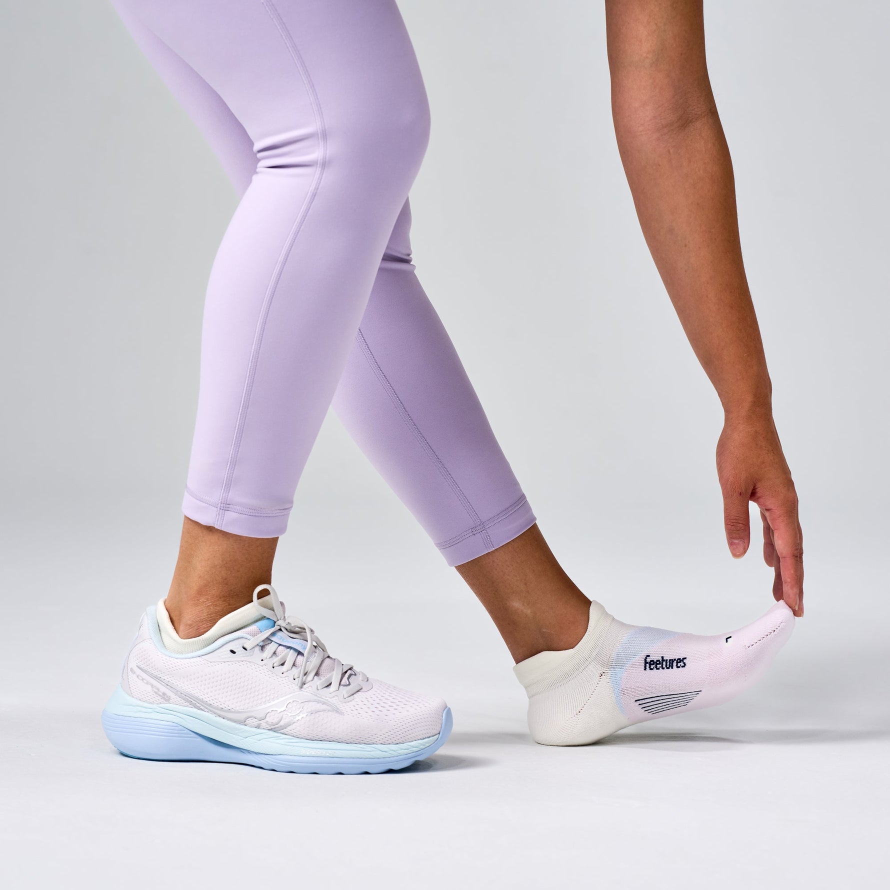 Feetures Elite Light Cushion Tab socks in White Rose worn with light blue running shoes