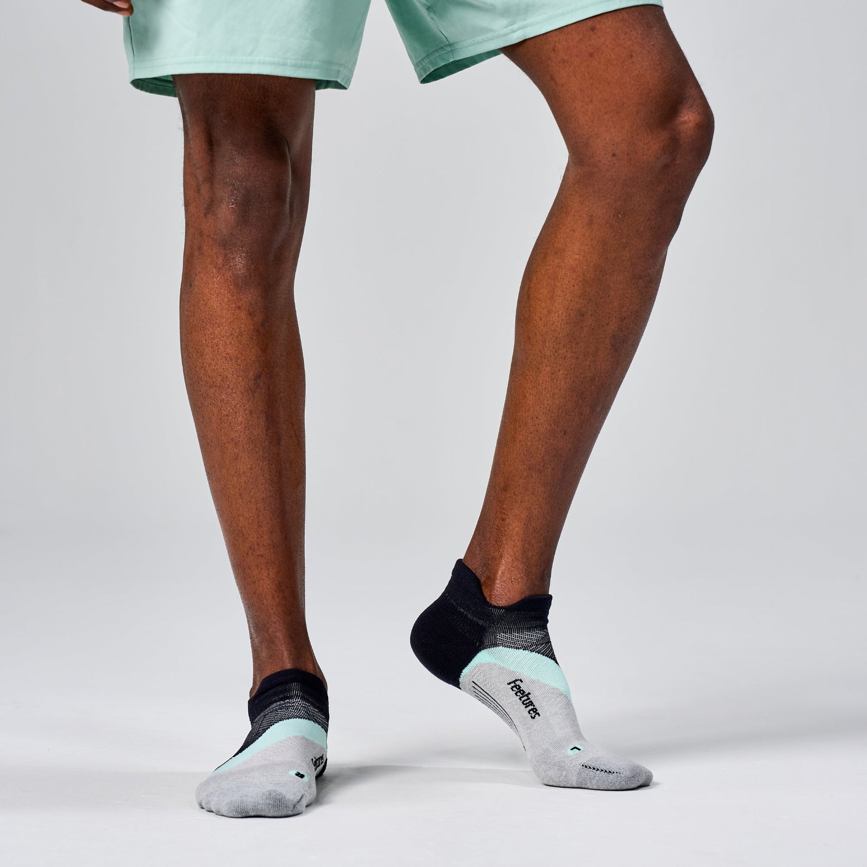 Feetures Elite Light Cushion Tab socks in black with mint and gray details