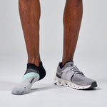 Feetures Elite Light Cushion Tab socks in navy and boost blue on runner's feet