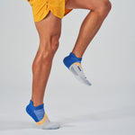 Person wearing Feetures Elite Light Cushion Tab socks in blue and orange colorway