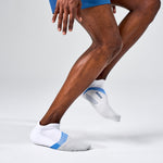 Feetures Elite Light Cushion Tab socks in white with blue accents on model's feet