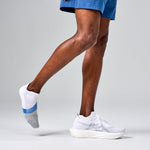 Feetures Elite Light Cushion Tab running socks in white with blue stripe on runner's feet