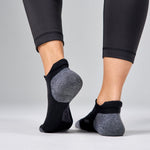 Feetures Elite Max Cushion Tab socks in black and grey worn on feet