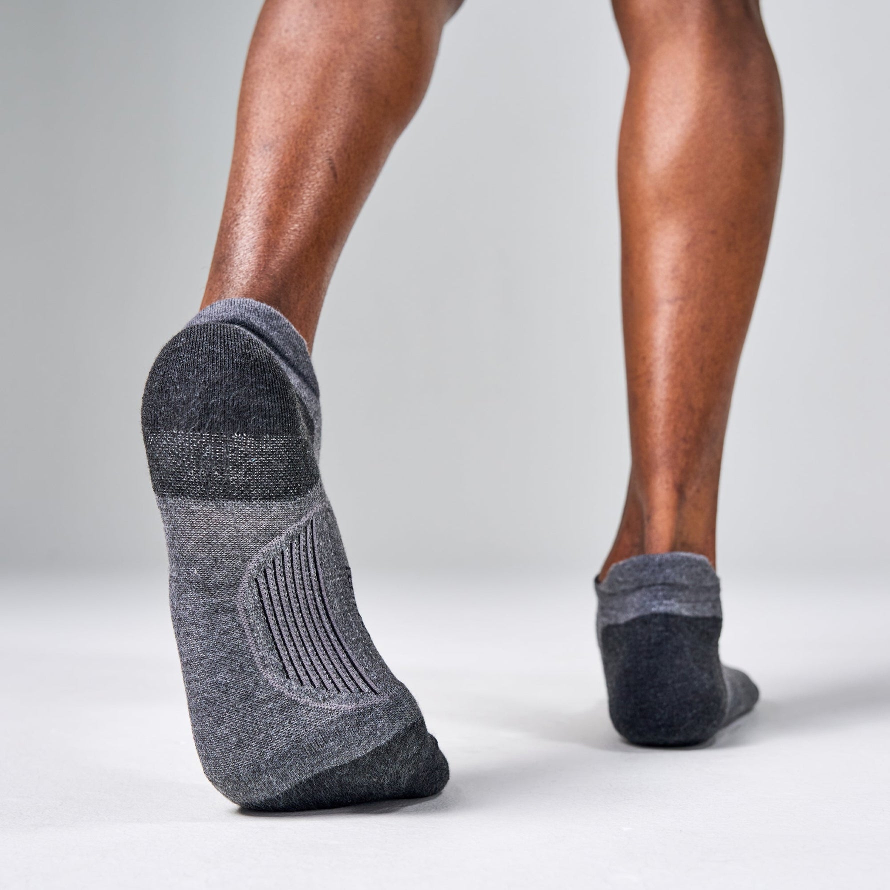 Feetures Elite Max Cushion Tab socks in grey worn on feet walking