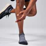 Feetures Elite Max Cushion Tab socks in grey on runner's feet