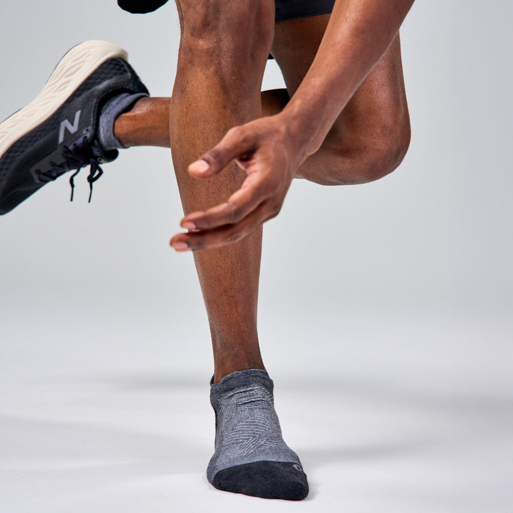 Feetures Elite Max Cushion Tab socks in grey on runner's feet