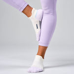 Feetures Elite Max Cushion Tab socks in white with purple accents on model's feet