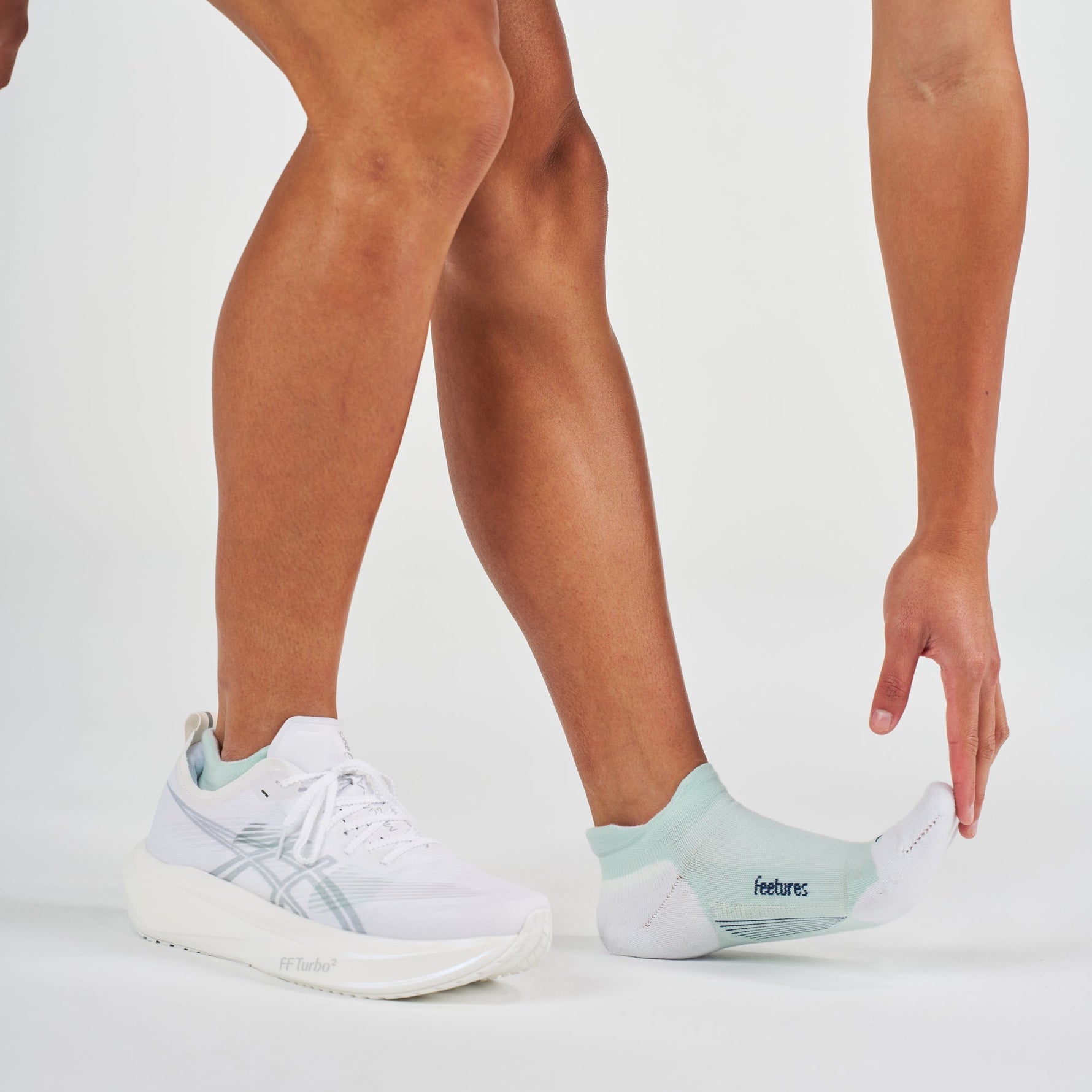 Feetures Elite Max Cushion Tab socks in Stone Ivy worn with white ASICS running shoes