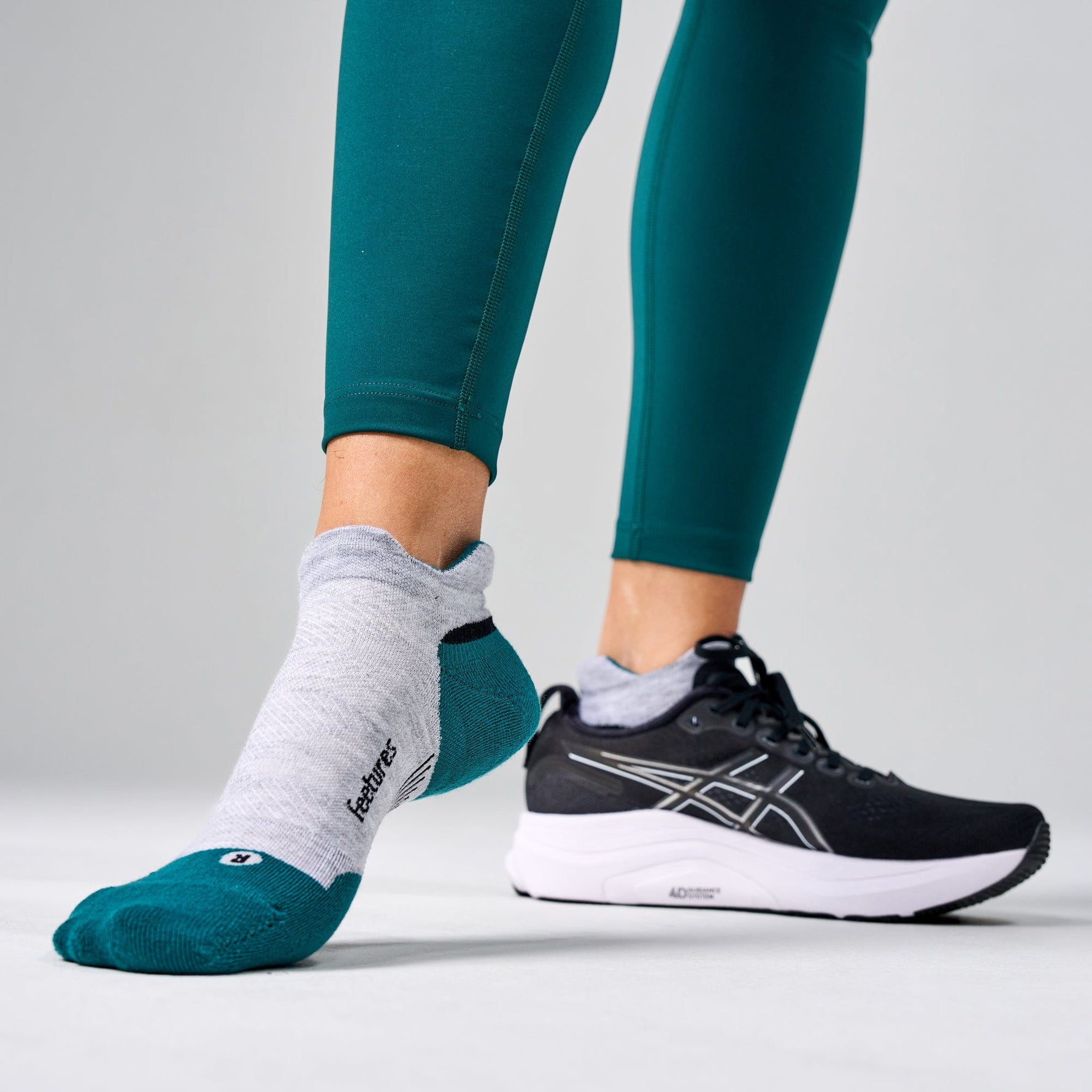 Feetures Elite Max Cushion Tab socks in Stone Ivy worn with black ASICS running shoes