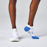 Feetures Elite Max Cushion Tab socks in white with blue accents worn with athletic shoes
