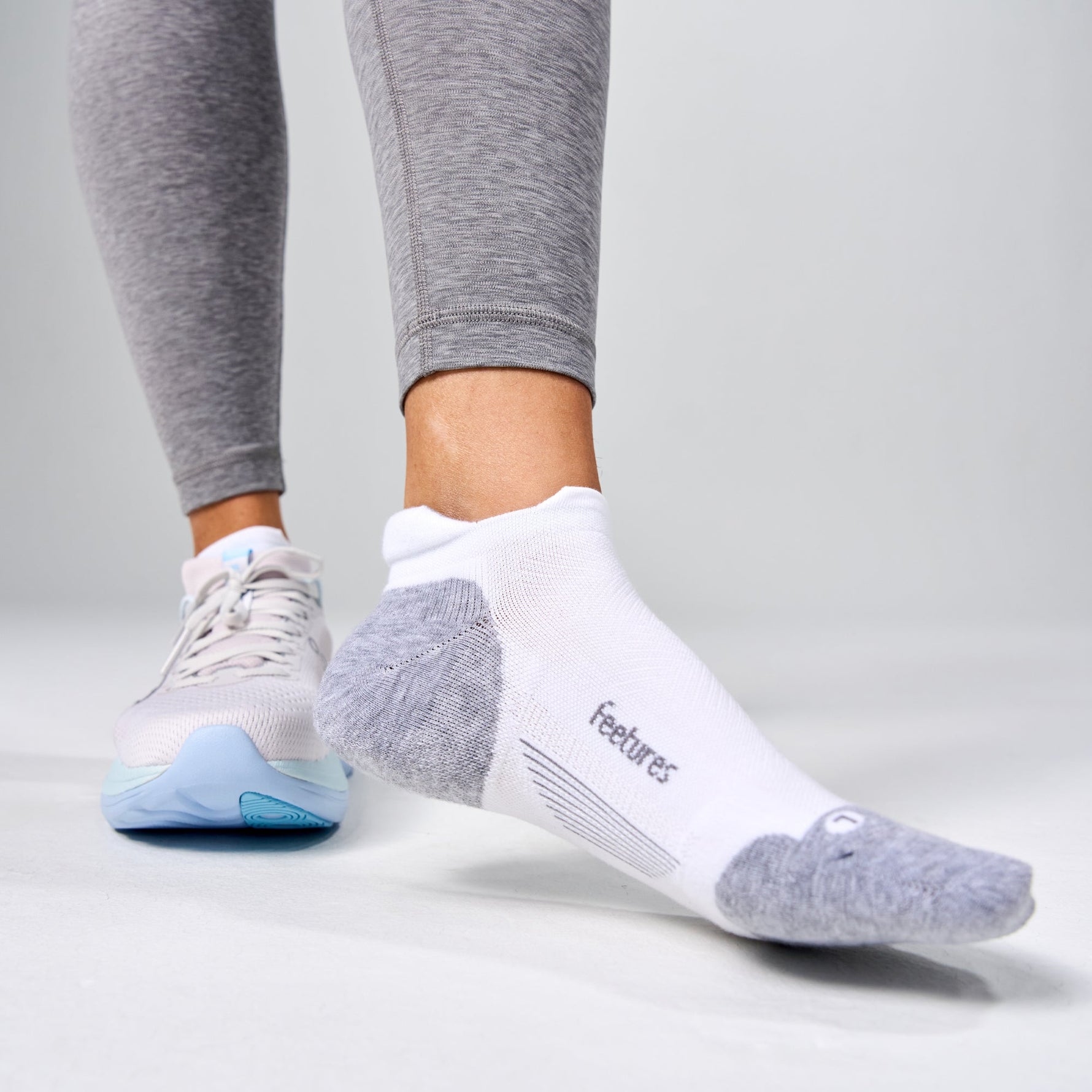 Feetures Elite Max Cushion Tab socks in white with gray accents on feet