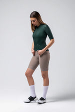 Woman wearing Gobik Infinity short sleeve cycling jersey in bunker green with cycling shorts