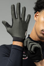 Model wearing GOBIK Lynx cycling gloves in army green with textured grip pattern