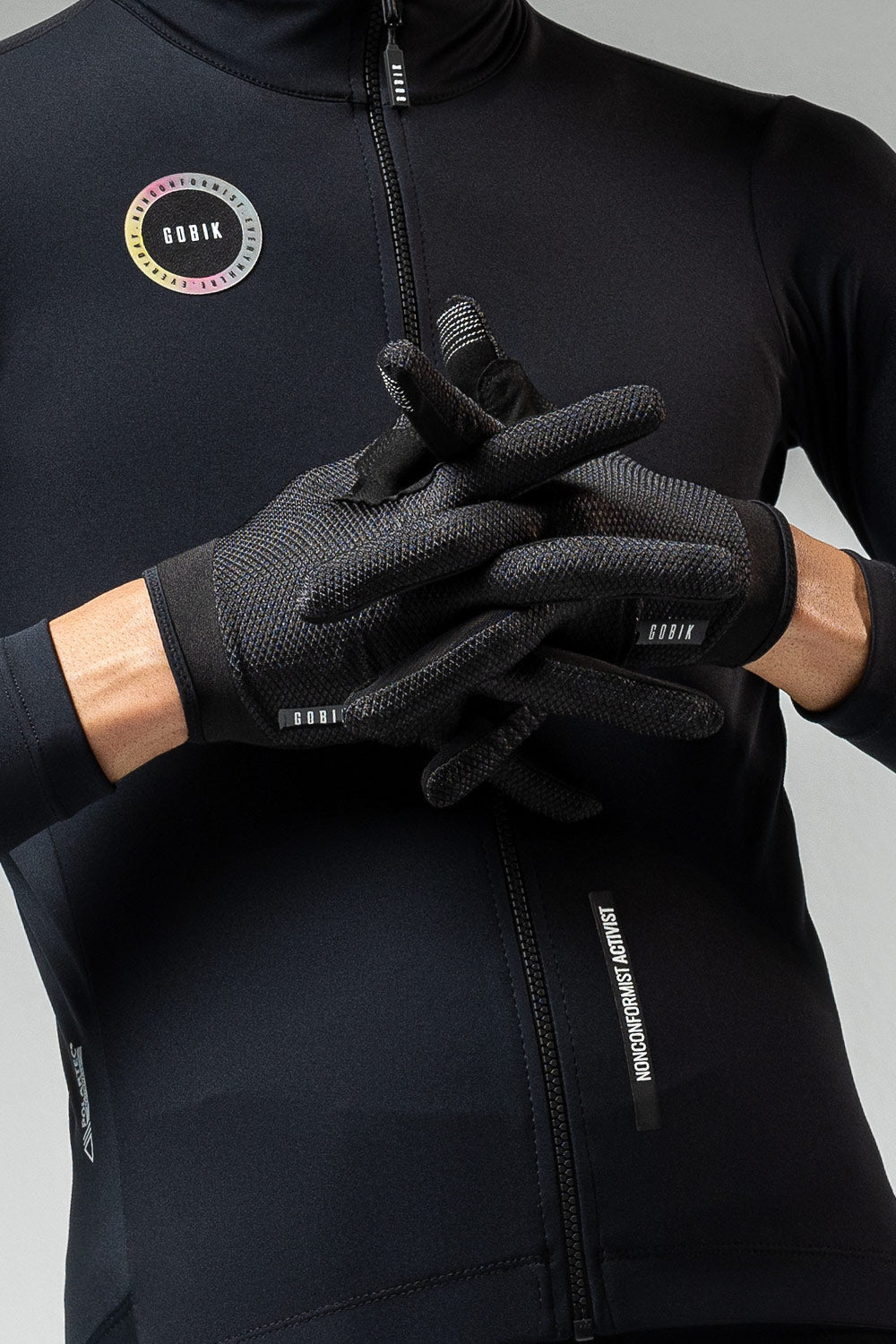 Gobik Lynx black cycling gloves worn with matching black cycling jacket