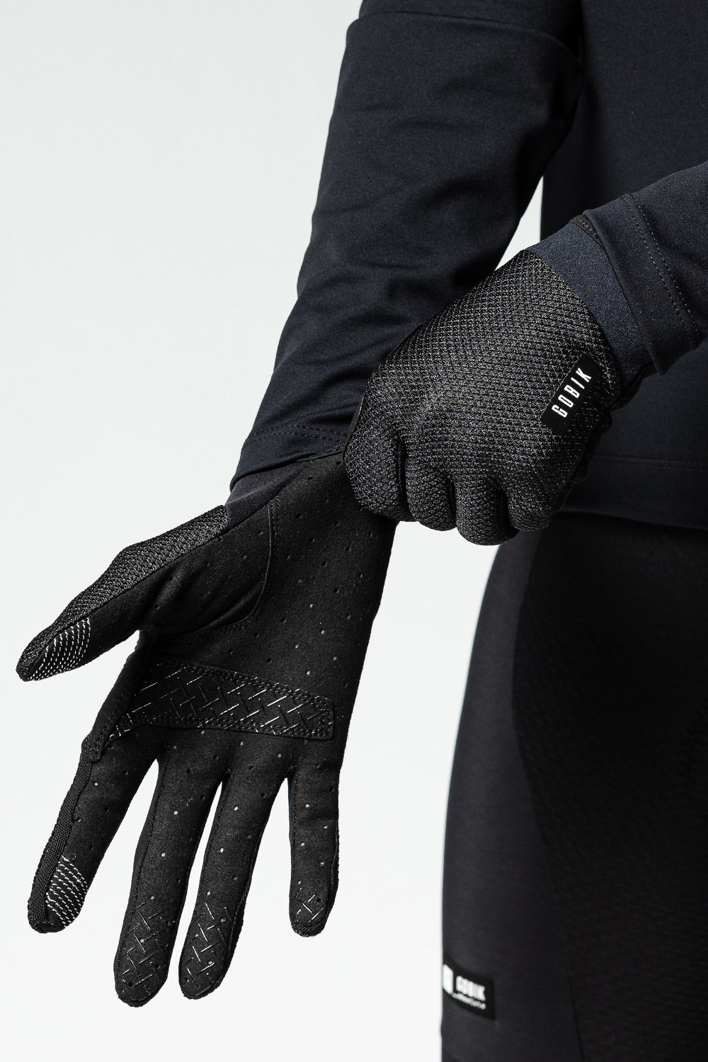 Black Gobik Lynx cycling gloves with textured grip palms on model hands