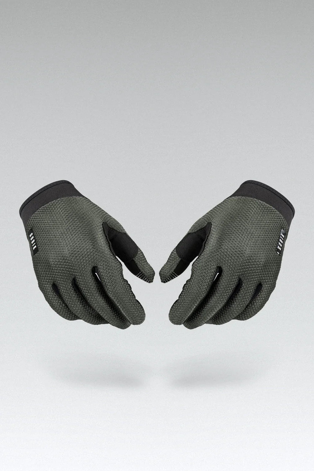 Pair of olive green Gobik Lynx cycling gloves with black fingertips on gray background