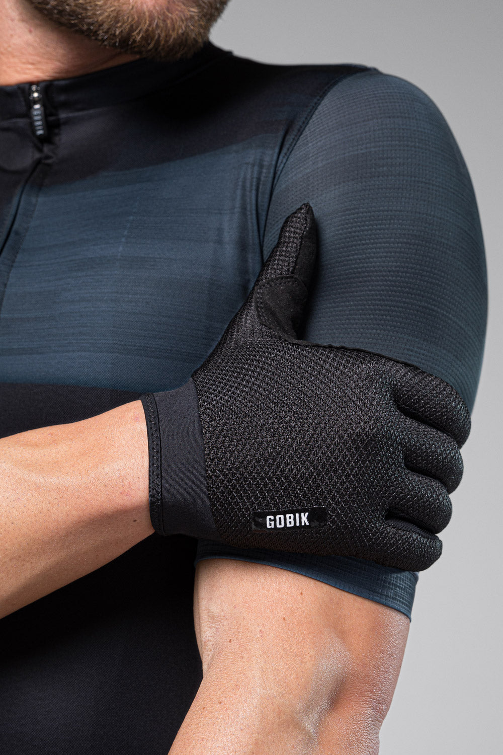 Black Gobik cycling gloves worn by model in professional studio setting