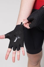 Black Gobik cycling gloves with fingerless design and ventilation perforations being worn