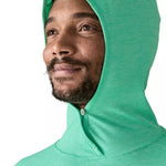Man wearing bright green Patagonia hooded sun protection shirt with hood up