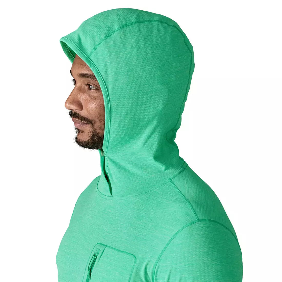 Man wearing bright green Patagonia hooded sun protection shirt, side profile view