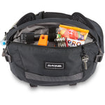 Black Dakine Hot Laps 5L fanny pack with contents displayed in open compartment