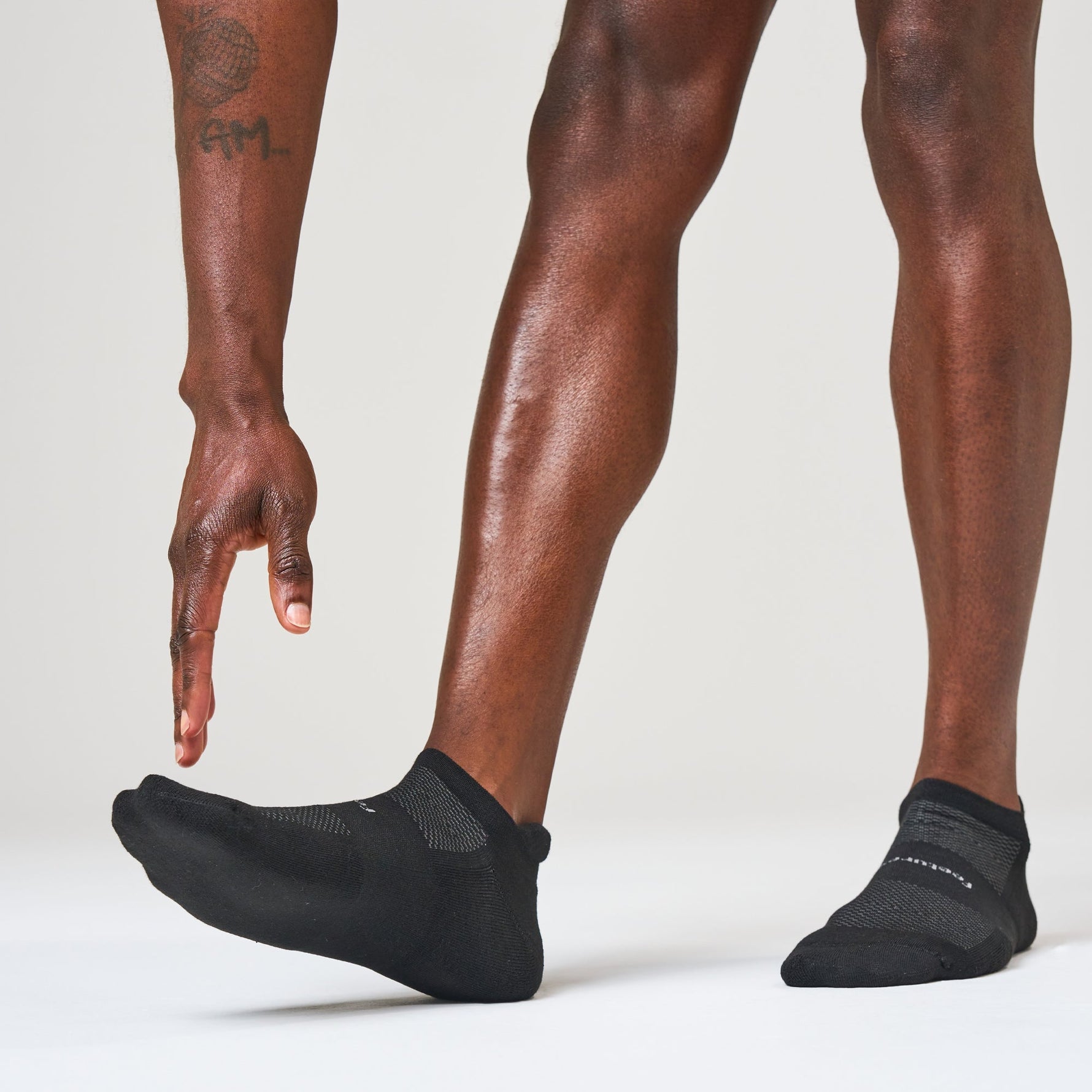 Black Feetures High Performance Max Cushion Tab socks on model's feet