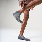 Person wearing Feetures heather grey athletic ankle socks with cushioned sole