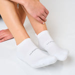 Person wearing white Feetures cushioned tab socks while adjusting them