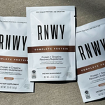 Three RNWY Complete Protein chocolate supplement packets with white and brown packaging design