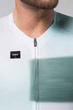 Gobik cycling jersey with white to emerald green gradient and zip detail