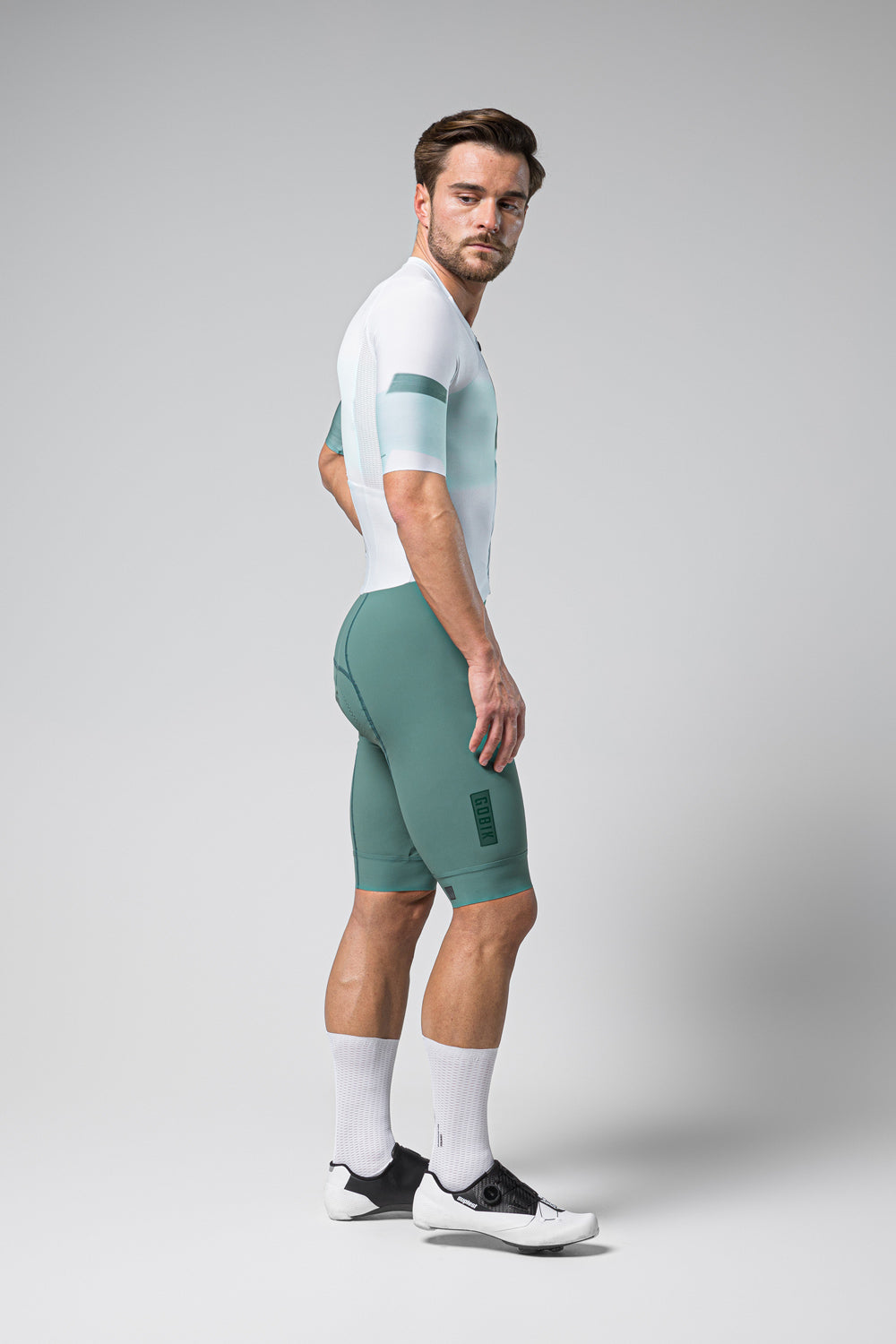 Male cyclist wearing Gobik Aero Brooklyn cycling suit in emerald green with white accents