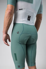 Gobik Brooklyn Aerosuit in sage green showing rear view with cycling shorts